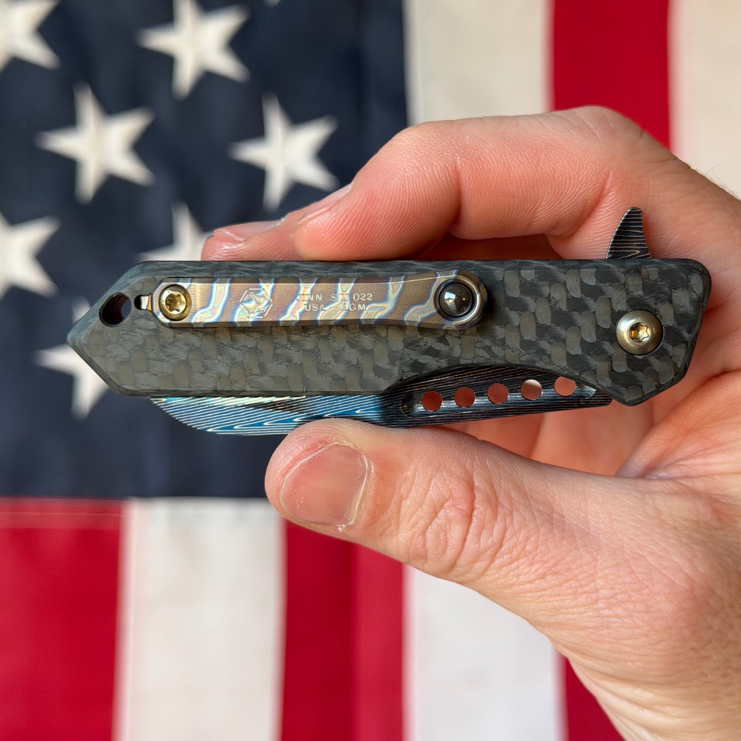 Heretic Knives Jinn Manual Knife – Carbon Fiber Chassis, Vegas Forge Herringbone Damascus, Hand Ground Blued Blade, Flamed Titanium Clip – Serialized – Made in USA (S/N 022)